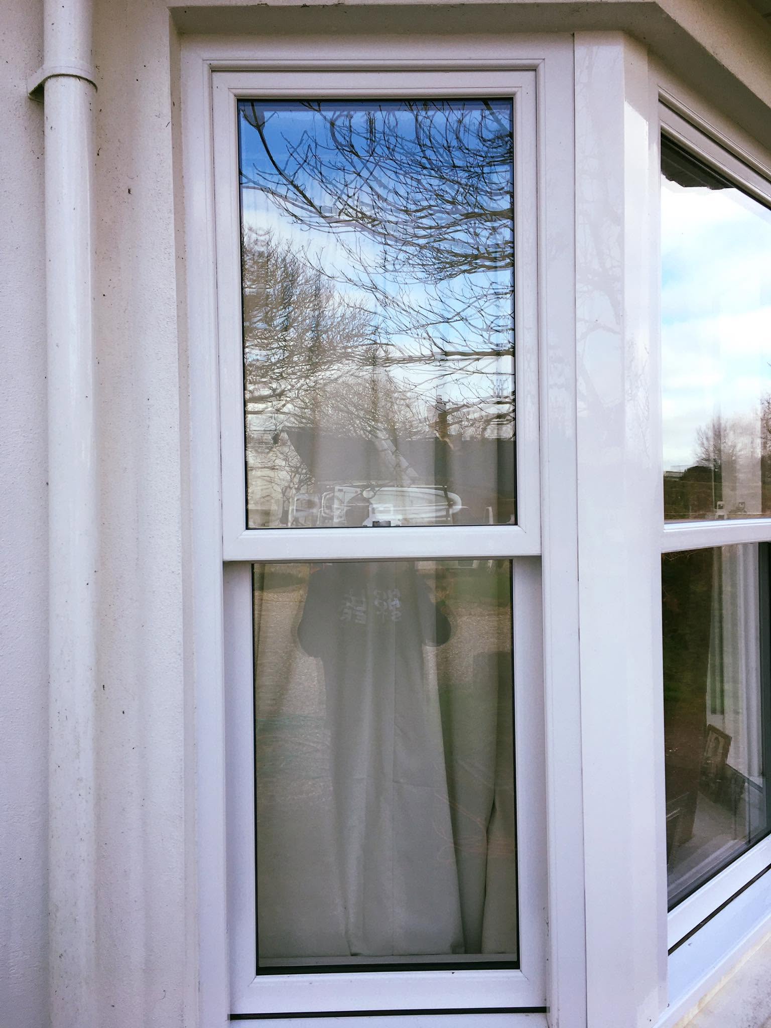 Window cleaner squeegeeing a large window until it is spotless